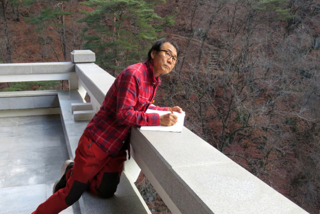 국제친선전람관 전망대에서 묘향산을 화첩에 담고있는 권용섭 화가.