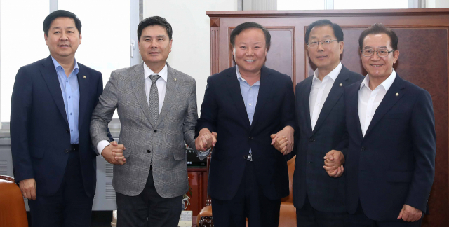 김재원 예결위원장(가운데)과 구윤철 기획재정부 2차관(왼쪽부터), 바른미래당 소속 지상욱 간사, 더불어민주당 소속 윤후덕 간사, 자유한국당 이종배 간사가 30일 오후 국회에서 열린 추가경정예산안 등 조정소위원회에 앞서 손을 맞잡고 있다. 연합뉴스