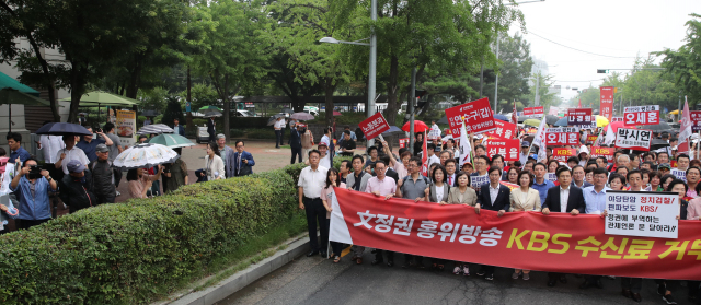 자유한국당 황교안 대표, 나경원 원내대표를 비롯한 의원들과 당원들이 25일 오전 서울 국회의사당역 앞에서 열린 KBS 수신료 거부를 위한 전국민 서명운동 출정식을 마친뒤 행진하고 있다. 연합뉴스