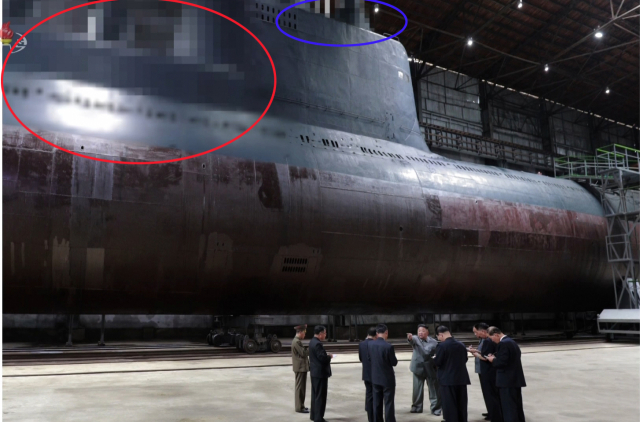 김정은 북한 국무위원장이 새로 건조한 잠수함을 시찰했다고 조선중앙TV가 23일 보도했다. 중앙TV는 시찰 장면이 담긴 사진을 공개하면서 잠수함에서 SLBM 발사관이 위치했을 것으로 추정되는 부분(붉은 원)과, 함교탑 위 레이더와 잠망경 등이 위치했을 것으로 추정되는 부분(파란 원)을 각각 모자이크 처리했다. [국내에서만 사용가능. 재배포 금지. For Use Only in the Republic of Korea. No Redistribution] 연합뉴스