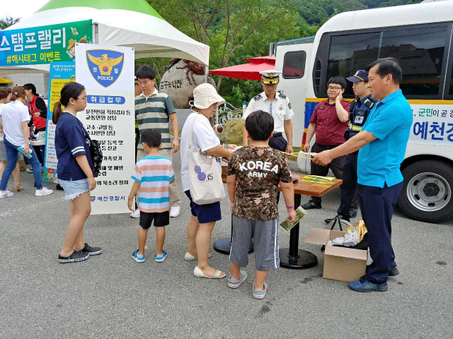 지난달 31일 예천경찰서 직원들이 예천곤충패스티벌이 열리는 곤충생태원 일대에서 장날 파출소를 운영, 관람객을 상대로 휴가철 사고 예방을 위한 홍보물을 나눠주고 있다. 예철경찰서 제공