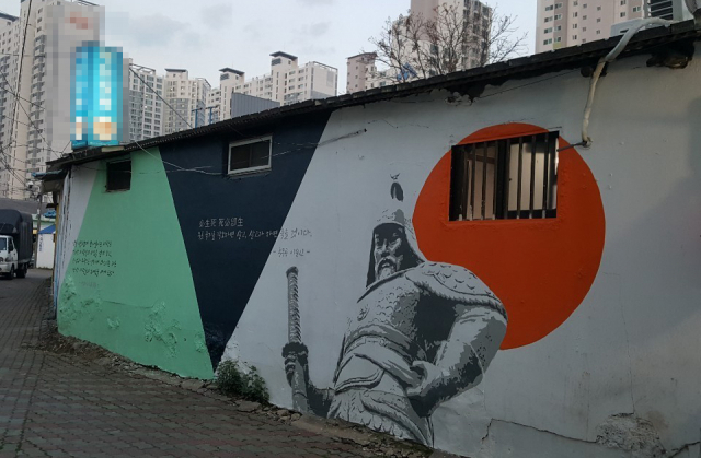 흰 바탕에 그려진 이순신 장군 벽화 뒤로 일장기를 연상케 하는 붉은 원이 그려져 있어 논란을 사고 있다. 사실 자세히 보면 붉은 색이 아니라 주황색 원이다. =독자 제공