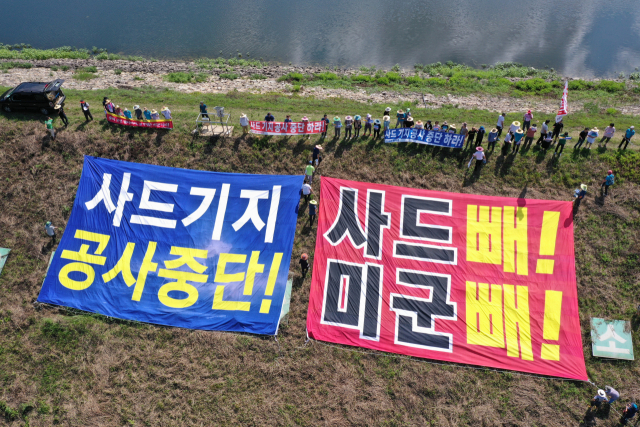 31일 오후 경북 성주군 초전면 소성리 마을회관 앞에서 소성리사드철회성주주민대책위원회, 사드배치반대김천시민대책위원회, 원불교성주성지수호비상대책위원회 등 6개 단체로 구성된 사드철회 평화회의 관계자들이 사드(THAAD·고고도미사일방어체계) 기지 내 공사를 반대하는 기자회견을 한 후 인근 소성리 저수지에서 대형 현수막을 펼치는 퍼포먼스를 하고 있다. 연합뉴스
