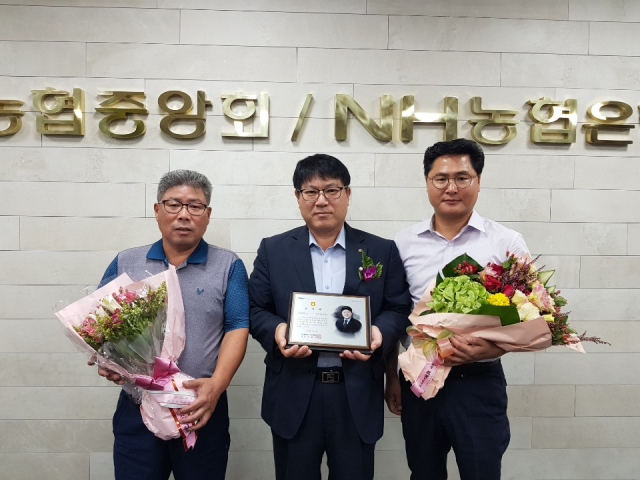 이영환 농협 성주군지부장(가운데)가 표창패를 들고 기념촬영을 하고 있다. 농협 성주군지부 제공