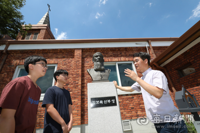 11일 대구 서구 상리동 새방골 성당에 세워진 대구본당 초대 신부인 김보록 신부의 흉상 앞에서 김형수 주임신부가 학생들에게 대구에서 가장 오래된 131년의 역사를 가진 본당이라는 설명을 하고 있다. 정운철 기자 woon@imaeil.com