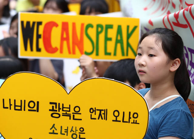7일 서울 종로구 옛 일본대사관 앞에서 열린 제1399차 일본군 성노예제 문제해결을 위한 정기 수요시위에서 참석자가 관련 내용의 피켓을 들고 있다. 연합뉴스