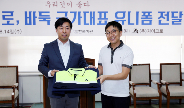 목진석 바둑 국가대표팀 감독(왼쪽)이 14일 서울 성동구 한국기원에서 국내 스포츠 업체 자이크로 최장영 대표이사에게 지원받은 유니폼을 전달 받고 있다. 대표팀은 이날 협약을 통해 올해 일본 브랜드 데상트에서 주문 제작한 유니폼을 자이크로의 국산 유니폼으로 교체했다. 다만 기존 데상트 유니폼을 폐기하지는 않고, 태극마크만 뗀 채 개인 판단에 따라 사용하기로 했다. 연합뉴스