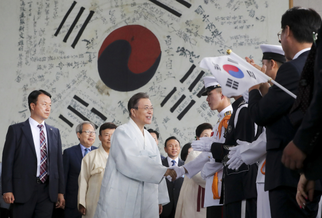 문재인 대통령이 15일 충남 천안시 독립기념관에서 열린 제74회 광복절 경축식에서 광복군이 서명한 대형 태극기를 배경으로 장병들을 격려하고 있다. 연합뉴스