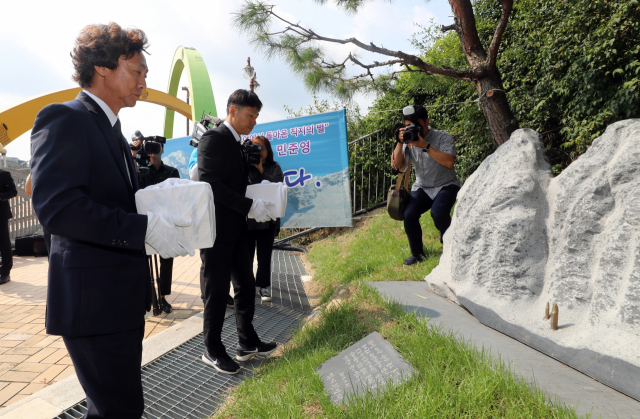 17일 오전 고(故) 박종성 대원의 형 종훈씨, 최인배 한국산악구조대 부대장, 고(故) 민준영 대원의 동생 규형씨가 안나푸르나 히운출리 북벽 아래에서 10년 전 실종됐던 직지원정대 소속 고 민준영·박종성 대원의 유골함을 청주 고인쇄박물관 추모 조형물 앞에 놓고 있다. 연합뉴스