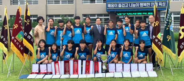 성주여중 하키팀이 학교 관계자와 교정에서 제33회 대통령기 전국하키대회 우승을 자축하고 있다. 성주여중 제공