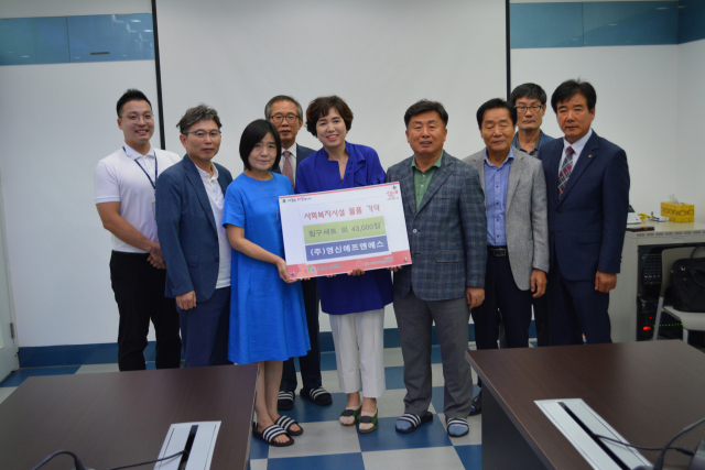 ㈜영신에프앤에스의 대표인 배영호·박순화 씨 부부가 26일 물품 기부 전달식을 갖고 기념촬영을 하고 있다. 김진만 기자