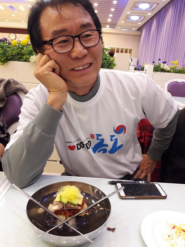 북한 안내원의 먹는 법 설명에 따라 필자가 고명을 제치고 냉면 그릇위에 젓가락을 X자로 걸쳐놓고 있다.