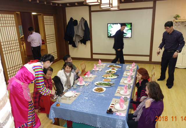 대동강수산물식당 민속료리실.한복을 곱게 차려입은 안내원이 막걸리를 따르고 있다.
