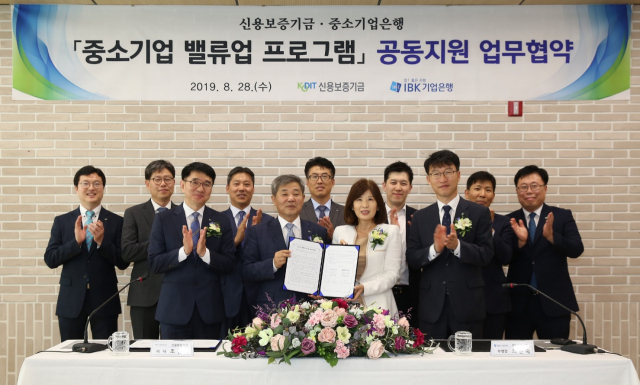 조경식 신용보증기금 이사(앞줄 왼쪽에서 두 번째부터)가 최현숙 중소기업은행 부행장과 중소기업 밸류업 프로그램 공동지원 업무협약을 체결 후 기념촬영을 하고 있다. 사진=신보