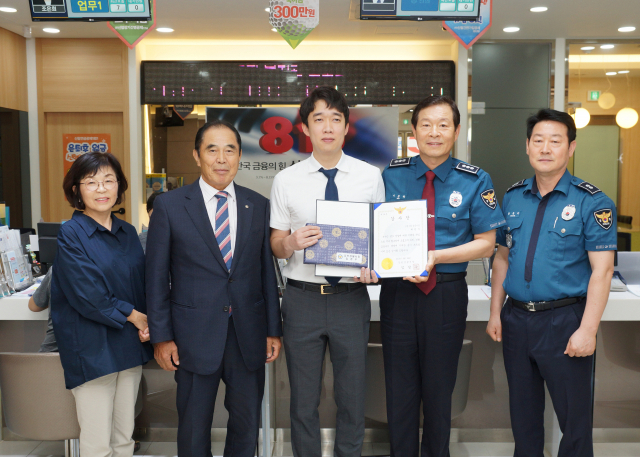 보이스피싱을 예방한 금융기관 직원에게 김천경찰서 관계자가 감사장을 전달하고 있다. 김천경찰서 제공