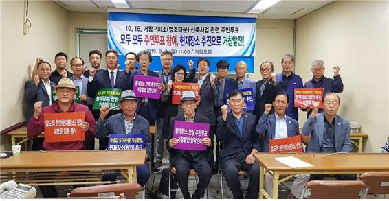 거창포럼 회원들이 거창군청 브리핑실에서 기자회견을 마치고 현재장소 찬성 투표 거창발전 앞당긴다 등의 손 피켓을 들고 사진촬영을 하고 있다.이상재기자