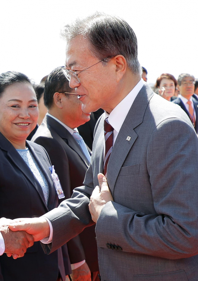 라오스 국빈방문 일정을 마친 문재인 대통령이 6일 오전(현지시간) 비엔티안 와타이 국제공항에서 전용기에 오르기 전 환송 나온 캄밍 대통령실 수석장관과 악수하고 있다. 연합뉴스