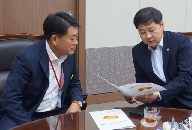 구교강(왼쪽) 성주군의회 의장이 구윤철 기획재정부 차관에게 성주군 당면 현안을 설명하고 있다. 성주군의회 제공