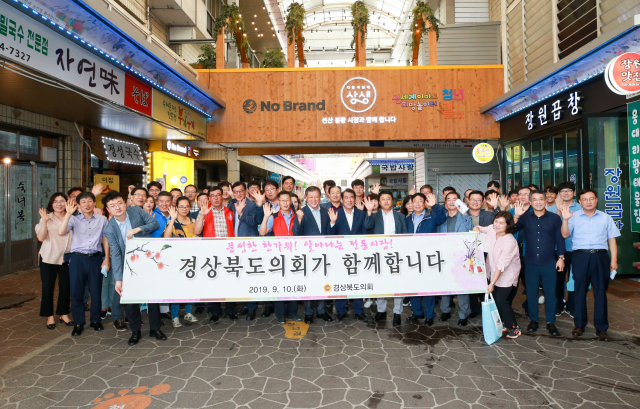 경북 구미 선산봉황시장에서 전통시장 장보기에 나선 경북도의회 관계자들이 기념촬영을 하고 있다. 경북도의회 제공