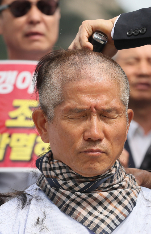 김문수 전 경기지사가 17일 오전 서울 청와대 앞 분수대 광장에서 조국 법무부 장관 임명에 반대하며 삭발을 하고 있다. 연합뉴스