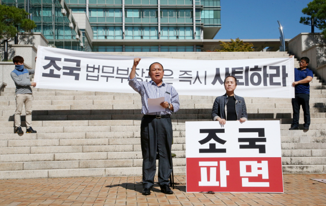18일 경북 포항시청 앞 광장에서 김순견 전 경북도 경제부지사가 부인 박재옥씨와 함께 삭발한 뒤 조국 법무부 장관 사퇴를 촉구하고 있다. 연합뉴스