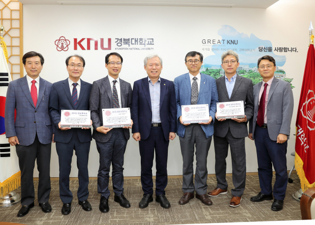최근 경북대 총장실에서 열린 연구시설 자체평가 수여식에서 임기병 연구산학처장, 신동현 국제개발연구원장, 백문창 세포·기질연구소장, 김상동 총장, 이영호 영남문화연구원장, 공성호 반도체융합기술연구원장, 김동균 연구산학부처장(왼쪽부터)이 기념사진을 찍고 있다. 경북대 제공