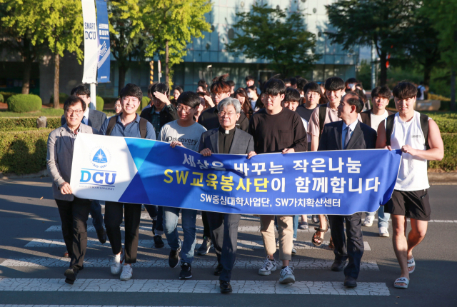김정우 대구가톨릭대 총장(가운데)와 학생들이 소프트웨어 교육봉사단 발대식을 마치고 캠퍼스를 행진하고 있다. 대구가톨릭대 제공