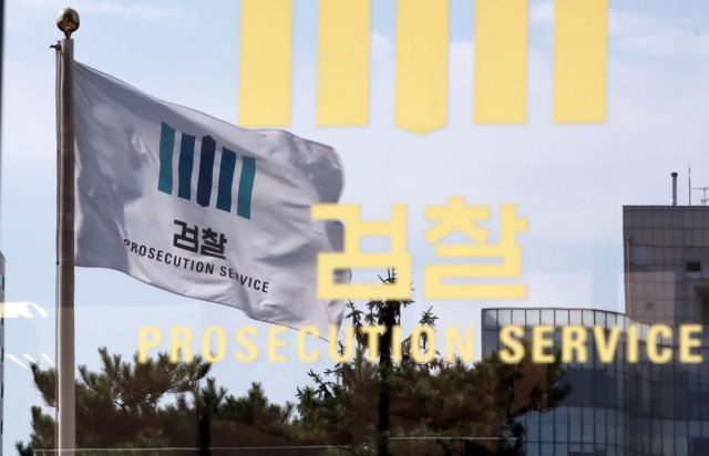 19일 오후 서울 서초동 서울중앙지검 1층 유리벽에 펄럭이는 검찰 깃발이 비치고 있다. 연합뉴스