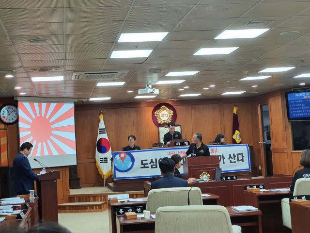 23일 열린 제258회 대구 중구의회 임시회 제2차 본회의에서 홍준연 구의원이 구정질의 도중 순종황제 동상 역사왜곡 등을 지적하며 일본 전범기를 비교해 설명을 하고 있다. 김우정 기자