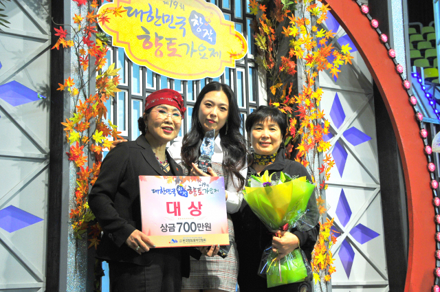 오미주(가운데)씨가 제19회 대한민국향토가요제 시상식에서 대상을 수상한 뒤 기념촬영하고 있다.