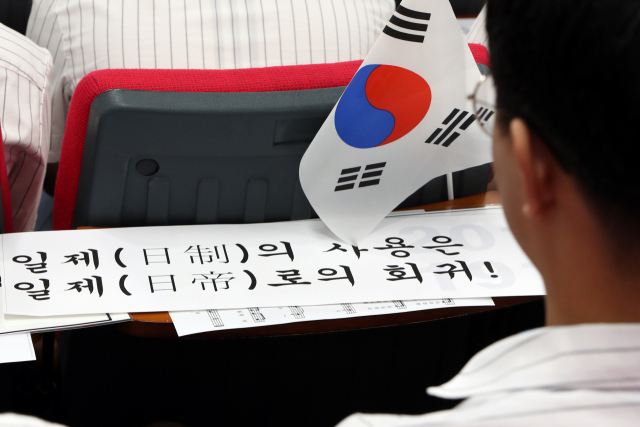 29일 오전 광주 서구 화정동 광덕고등학교에서 열린 경술국치 109주년 추념식에서 학생이 일본제품 불매를 다짐하는 손팻말을 바라보고 있다. 연합뉴스