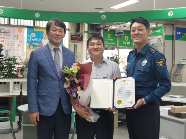 경북 청송경찰서는 1일 보이스피싱 범죄 피해를 막은 청송군 현서농협 김준석(가운데) 과장에게 표창장과 선물을 전달했다. 청송경찰서 제공