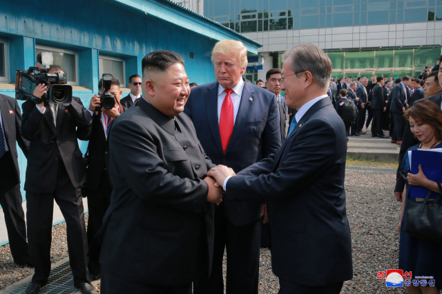 문재인 대통령과 김정은 북한 국무위원장이 지난 6월 30일 판문점에서 두손을 맞잡고 대화하고 있다. 가운데는 도널드 트럼프 미국 대통령.연합뉴스