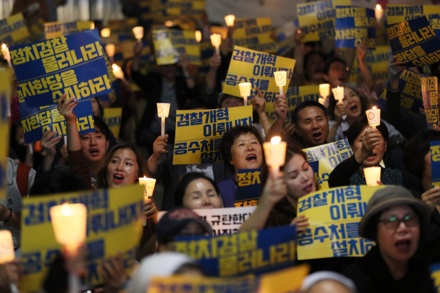 17일 오후 서울 서초구 서울중앙지검 앞에서 열린 검찰 개혁·사법적폐 청산 집회에서 참가자들이 촛불을 들고 구호를 외치고 있다. 연합뉴스
