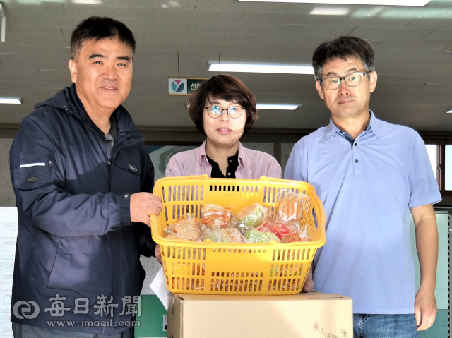 경북 영덕의 태풍 복구 지원을 나선 자원봉사자들을 위해 간식으로 카스텔라를 준비한 영해면 주민 김기락(오른쪽)·홍기숙 부부가 9일 창수면을 찾아 최일준 창수면장에게 물품을 전달하고 있다. 김대호 기자