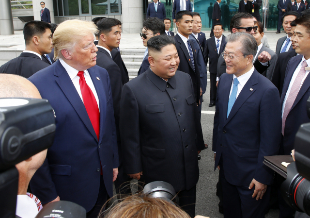 문재인 대통령(오른쪽부터), 북한 김정은 국무위원장, 미국 도널드 트럼프 대통령이 지난 6월 30일 판문점 남측 자유의 집 앞에서 만나 얘기를 나누고 있다. 연합뉴스
