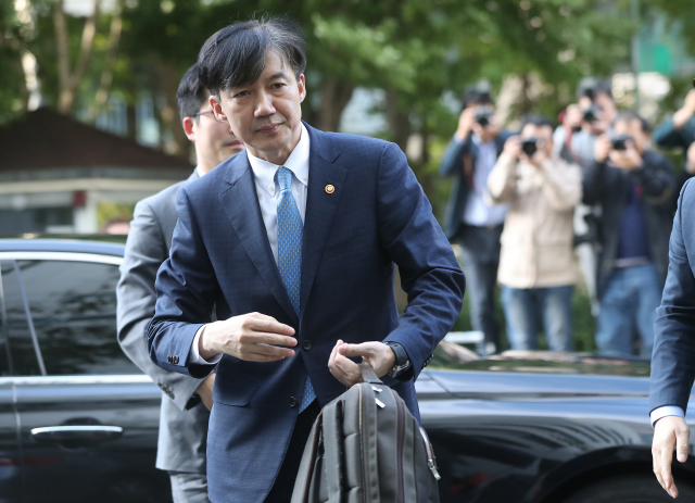 전격적으로 사의를 밝힌 조국 법무부 장관이 14일 오후 법무부 관계자로부터 가방을 받아들고 방배동 자택으로 들어가고 있다. 연합뉴스