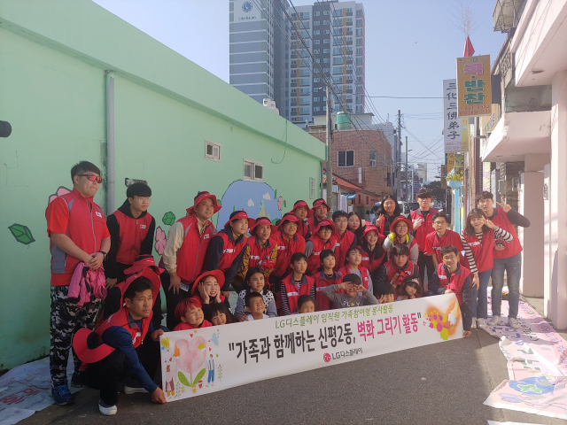 LG디스플레이㈜ 임직원 및 가족들이 구미 신평2동에서 노후된 담벼락에 벽화 그리기 봉사활동을 하고 기념촬영을 하고 있다. LG디스플레이 제공
