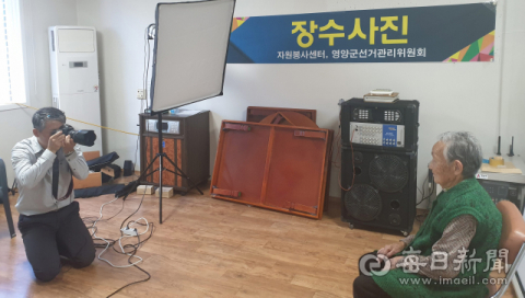 자원봉사 시범마을 행사에서 자원봉사자들이 어르신들에게 영정사진을 촬영해주고 있다. 영양군 제공