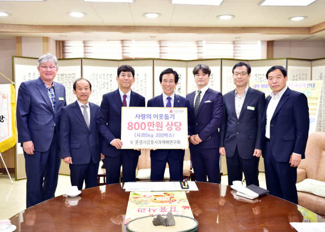 문경감홍사과재배연구회 박성오 회장(왼쪽에서 세 번째·찬미네농원 대표)이 지난 25일 고윤환 문경시장을 만나 감홍사과 5㎏ 200박스(800만원 상당)를 전달했다. 문경시 제공