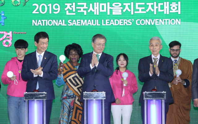 문재인 대통령이 29일 오후 수원실내체육관에서 전국새마을지도자대회 참석자들과 생명살림 퍼포먼스를 하고 있다. 퍼포먼스에서는 문 대통령과 내빈들이 신호대 버튼을 누르자 생명살림 실천과제 문구가 담긴 현수막이 펼쳐졌다. 왼쪽부터 진영 행정안전부 장관 문 대통령, 정성헌 새마을운동중앙회장. 연합뉴스