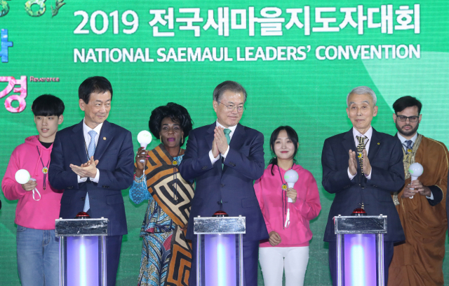 문재인 대통령이 29일 오후 수원실내체육관에서 전국새마을지도자대회 참석자들과 생명살림 퍼포먼스를 하고 있다. 왼쪽부터 진영 행안부 장관, 문 대통령, 정성헌 새마을운동중앙회장. 문 대통령과 내빈들이 신호대 버튼을 누르자 생명살림 실천과제 문구가 담긴 현수막이 펼쳐졌다. 연합뉴스