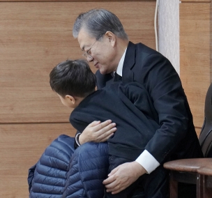 문재인 대통령이 30일 오전 부산 남천성당에 마련된 모친 고 강한옥 여사의 빈소에서 손주와 대화하고 있다. 연합뉴스