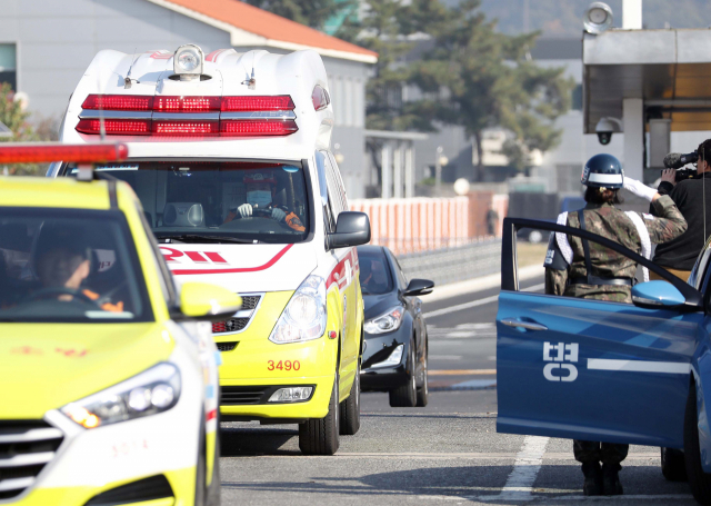 6일 오전 대구 공군기지에서 헌병이 독도 인근 해상 추락 헬기 탑승원의 시신을 옮기는 소방당국 차량 행렬을 향해 경례하고 있다. 연합뉴스