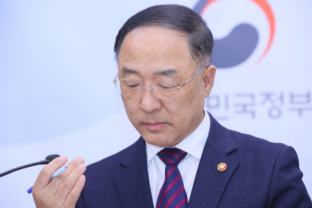 홍남기 경제부총리가 11일 세종시 정부세종청사 기획재정부에서 문재인 정부출범 2년반의 경제상황에 관한 소회를 말하기 전 마이크를 고쳐잡고 있다. 연합뉴스