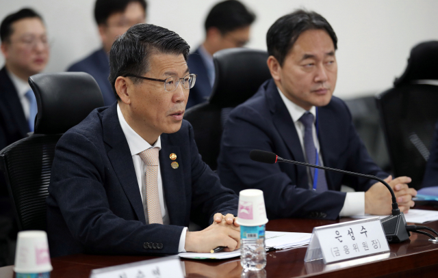 은성수 금융위원회 위원장(왼쪽)이 14일 오전 국회의원회관에서 열린 정무위원회 