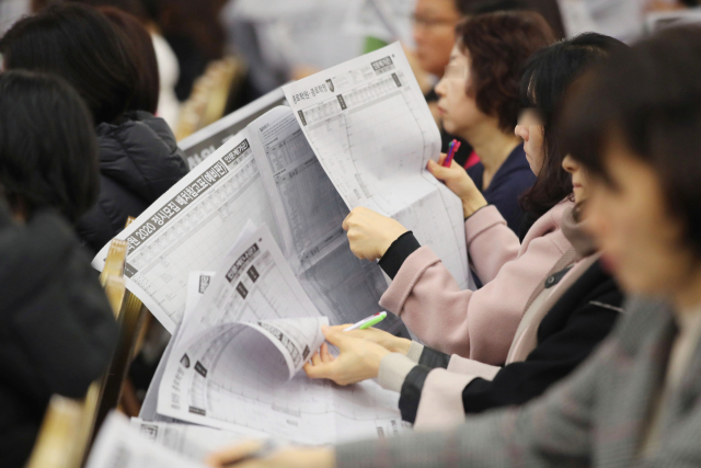 15일 서울에서 열린 한 입시업체의 정시 지원 전략 설명회에 참석한 수험생과 학부모들이 배치기준표를 유심히 들여다보고 있다. 연합뉴스