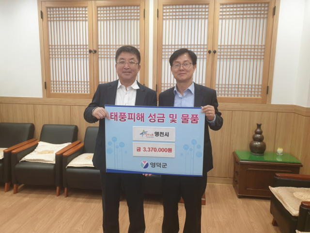 장상길(왼쪽) 영천부시장이 정규식 영덕부군수에게 태풍피해 복구성금 337만원을 전달하고 있다. 영천시 제공