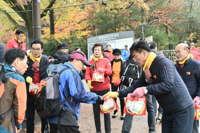 16일 서울시 서초구 청계산 원터골 등산로 입구에서 윤경희 청송군수가 한 등산객에게 청송사과를 나눠주고 있다. 청송군 제공