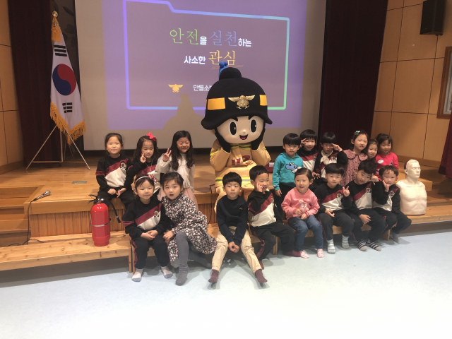 안동 꿈터유치원 원생들이 소방캐릭터 영웅이의 남자 캐릭터 웅이와 함께 소방교육을 받은 뒤 기념촬영을 하고 있다. 안동소방서 제공